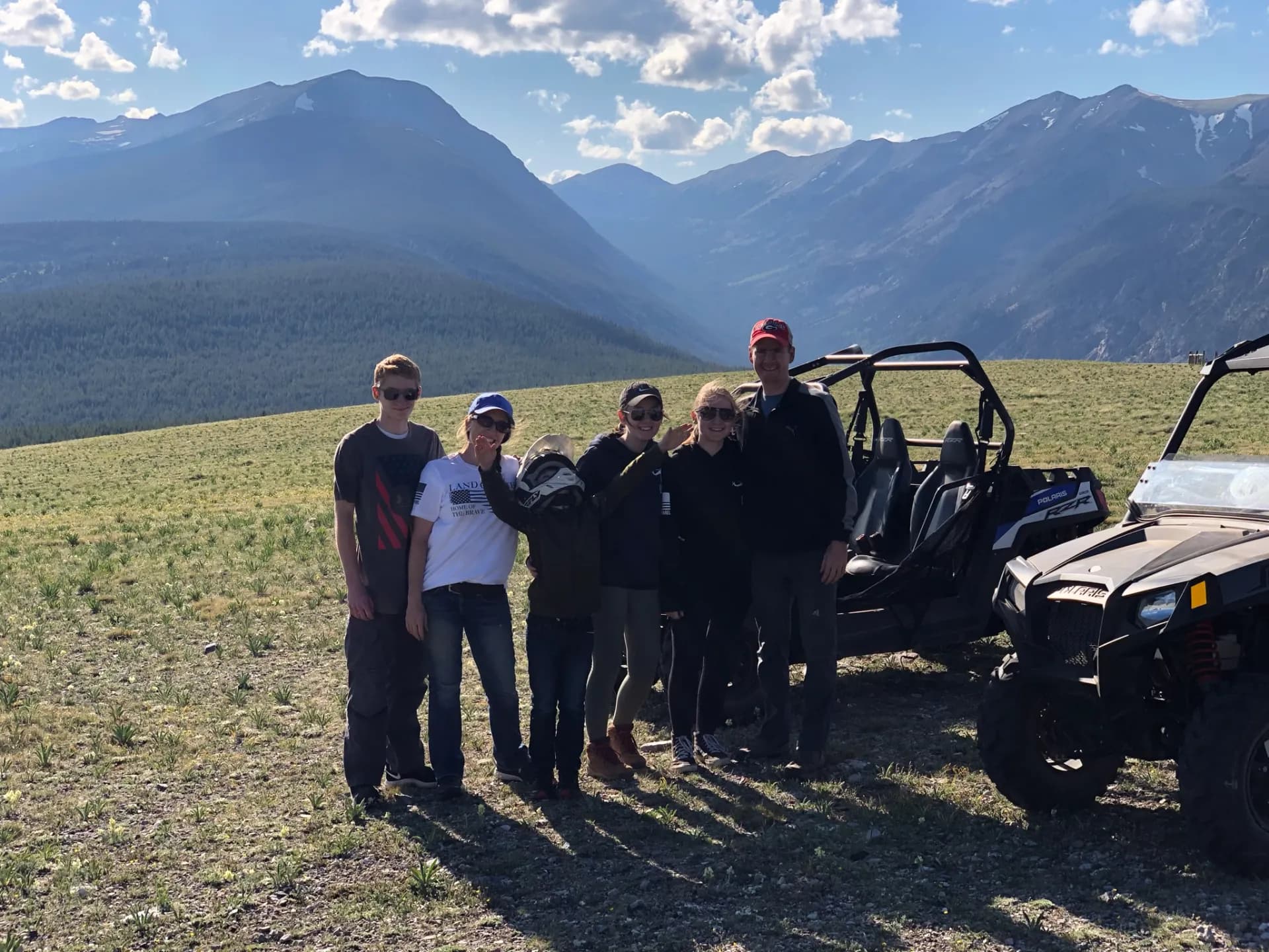Family with Polaris RZRs in front of the Montana mountains